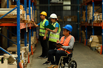 工人事故高清背景图片_坐轮椅的高级男经理和穿着安全制服的年轻工人检查货架上存储产品的数量