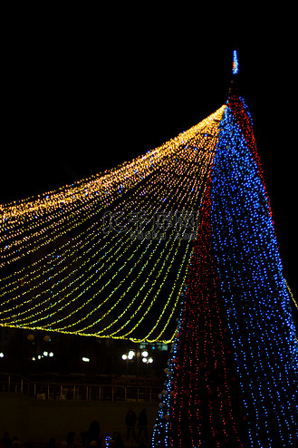考纳斯图片素材_广场上一棵装饰独特的主圣诞树在雨后反射的长曝光夜拍。