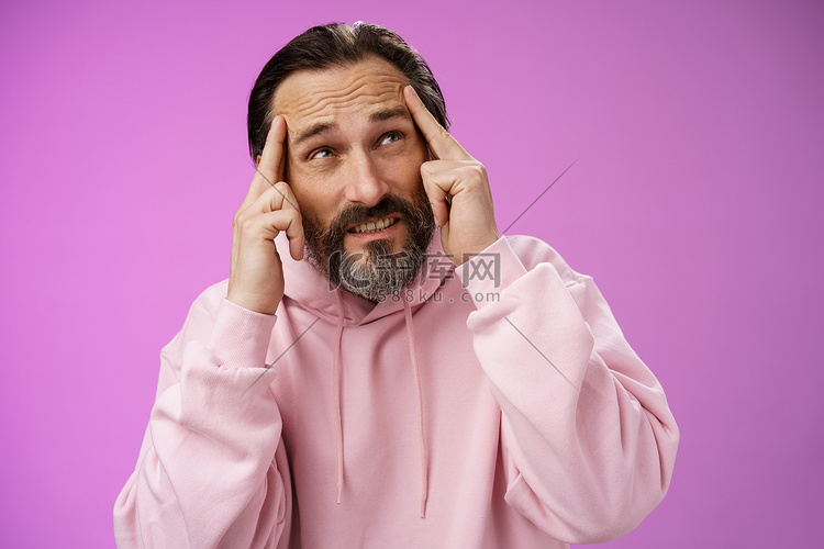 担心强烈不安的成熟男性作家无法创造想法站立压力触摸额头皱眉抬头看问题注意力不集中，站立紫色背景心烦意乱高清摄影大图-千库网