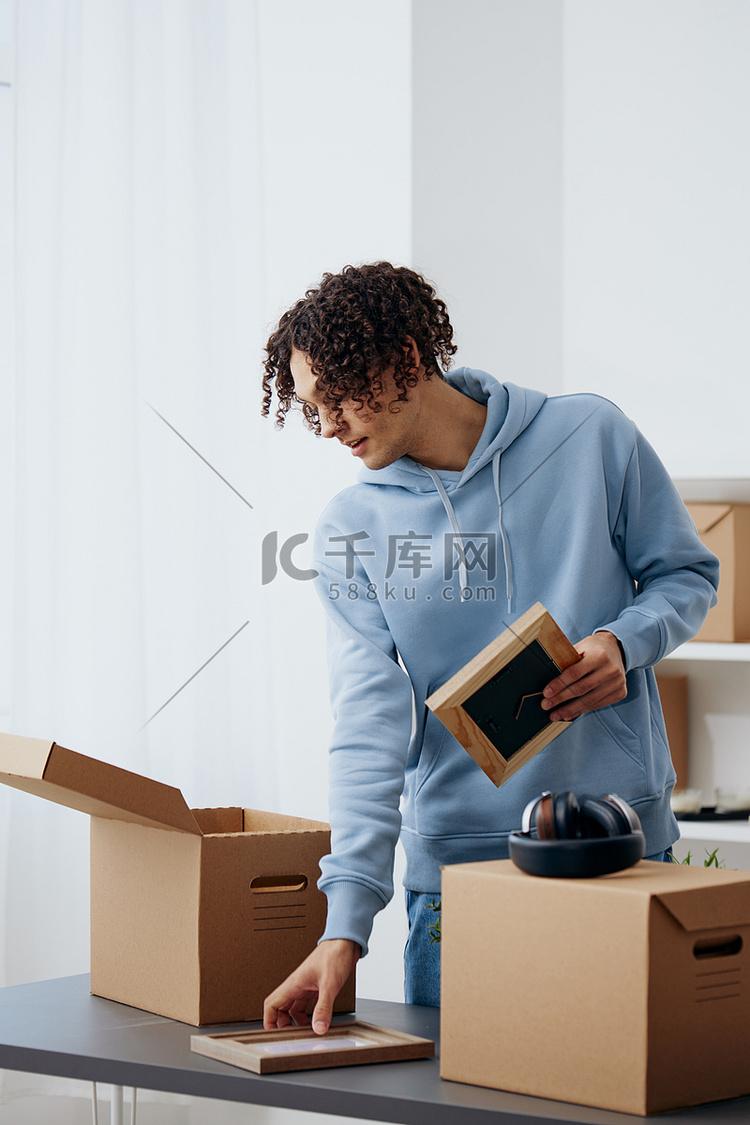 一个男人从房间里的盒子里拿出东西来整理东西的肖像高清摄影大图-千库网