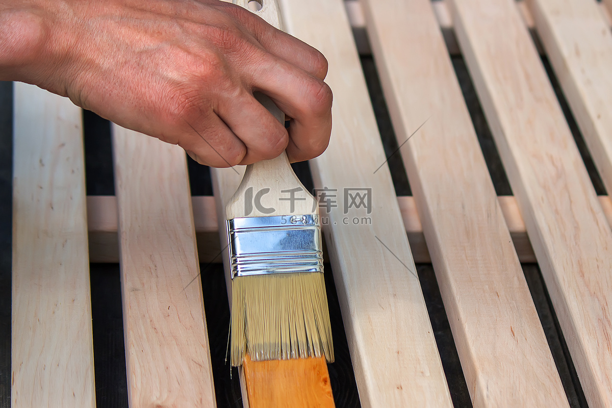 用清漆给木制家具上漆。高清摄影大图-千库网