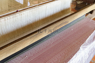 在传统织布机上用丝绸手工编织古代图案