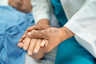 医生手牵着亚洲老年或老年老妇人的手,在护理医院病房里充满爱,关怀