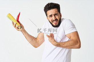 留着胡子的男人手里拿着蔬菜辣椒玉米