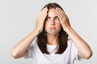 尴尬而震惊的年轻美女的特写镜头,面容尴尬,白色背景