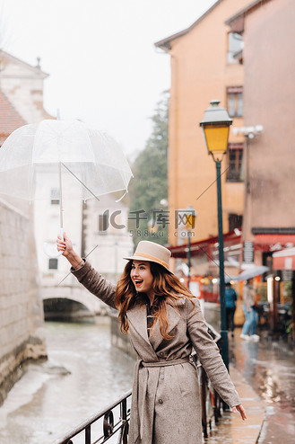 透明外套图片素材_美丽浪漫的女孩在一件外套和帽子与透明雨伞在