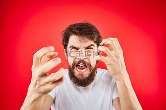 男人胡须国画图片素材_情绪化的留着胡须的男人用白色T恤的双手做出手势，表示侵略、不满的红色背景