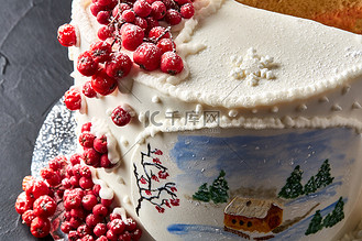 红金色蛋糕图片素材_冬天的蛋糕上覆盖着白色的糖霜，森林里有彩绘的房子，树木和红罗文。