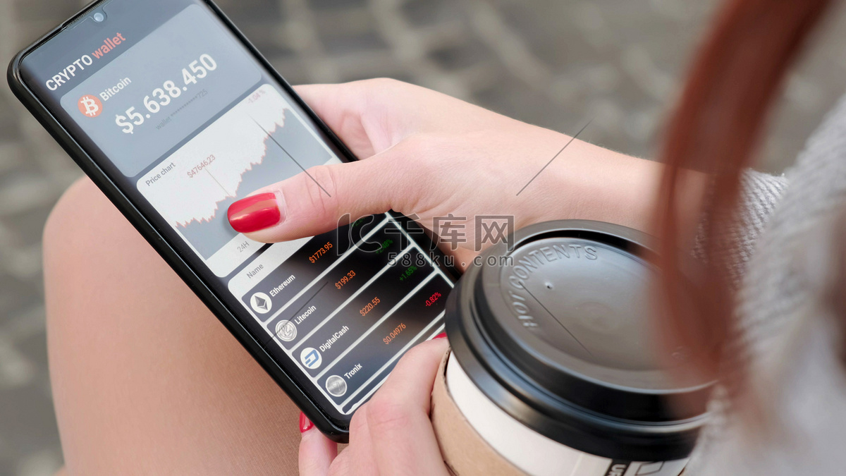 喝咖啡的小女孩分析比特币的价格，并在智能手机的移动应用程序中购买比特币。带有移动应用程序钱包加密货币的智能手机。高清摄影大图-千库网