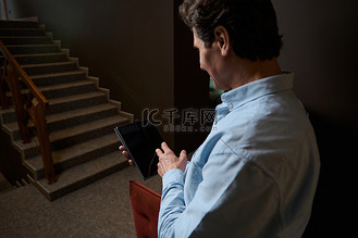 将注意力集中在销售经理的手上，数字平板电脑的空白黑屏上有广告复制空间。