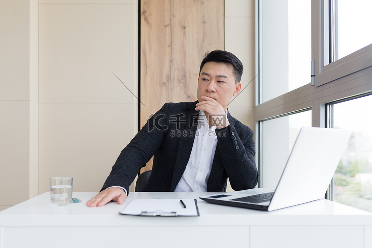 年轻的亚洲上班族在办公室工作时头痛，喝药丸用水。高清摄影大图-千库网