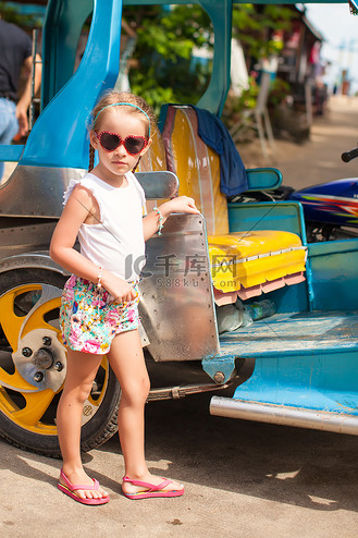 亚洲国家一辆开放式出租车附近的可爱小女孩