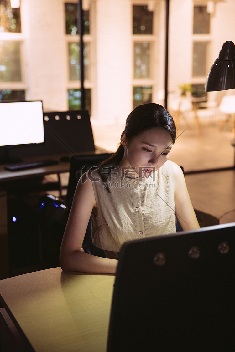 在办公室加班的年轻女士高清摄影大图-千库网
