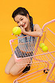 拿着网球的年轻女孩蹲在购物车旁