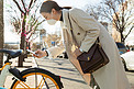 戴口罩的年轻女人扫码骑共享单车
