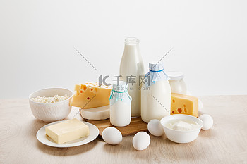 木制桌子上的各种新鲜有机奶制品和鸡蛋与白色隔离