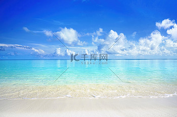 阳光明媚的日子美丽的沙滩上白沙飘扬碧绿的大海荡漾着平静的浪花