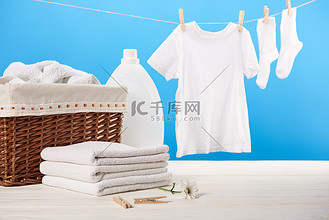 挂水珠图片素材_洗衣篮, 塑料容器与洗衣液, 一堆干净柔软的毛巾和白色衣服挂在晾衣绳上的蓝色  