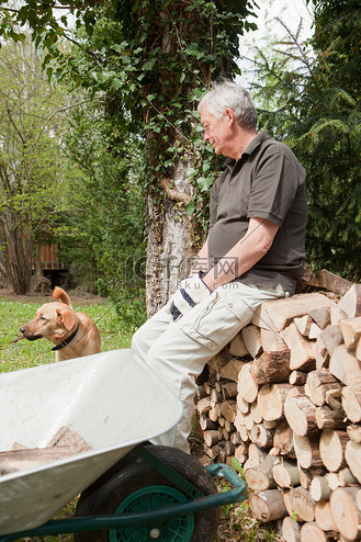 一位年长的男子在后院养狗休息