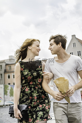 一对年轻夫妇手挽手穿过小镇