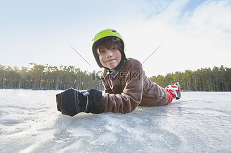 瑞典加夫勒冰冻的湖面上躺着的男孩的肖像