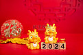 2024春节两个龙摆件红色背景摆放摄影图配图