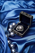 优雅的丝缎蓝色丝质戒指盒，镶有黑珍珠
