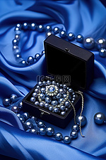优雅的丝缎蓝色丝质戒指盒，镶有黑珍珠