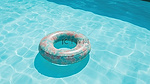 顶视图暑假背景充气橡胶环漂浮在游泳池水上，具有 3D 渲染和充足的复制空间