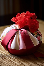 桌子上有一顶带有红色蝴蝶结的玫瑰色丝质帽子