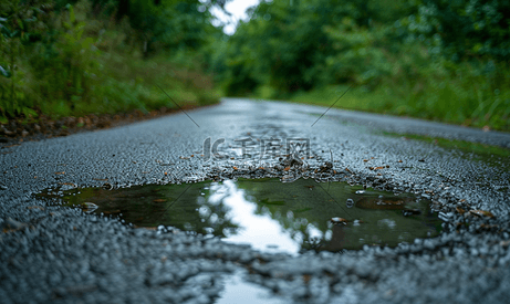 雨中铺好的道路上有雨滴的水坑