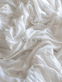 白色皱巴巴的织物纹理起波纹的表面宽背景特写夜间睡眠后卧室里未整理的床单柔和聚焦