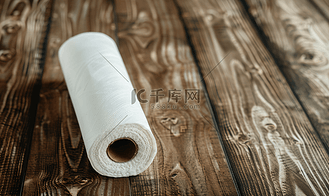 香酥山药卷高清背景图片_棕色木质背景上一卷厨房毛巾物体上的白色纸管