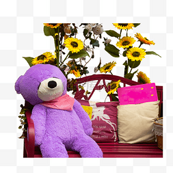 一只坐着的玩具熊和一些太阳花