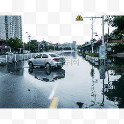 城市街道马路图片_城市大雨雨水里的汽车在马路上停