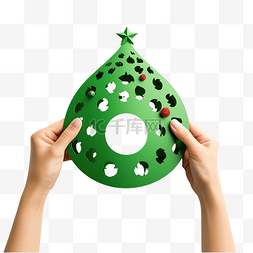 女手拿着绿纸圆孔中的小创意圣诞