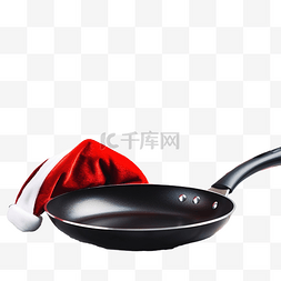 白木桌上带圣诞帽的煎锅或煎锅