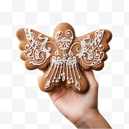 一只手拿着天使形状的圣诞姜饼
