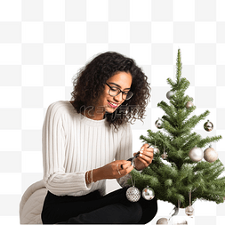 美国室内图片_戴眼镜的印度女孩坐着装饰圣诞树