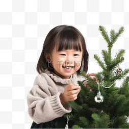 亚洲小女孩正在装饰圣诞树，享受