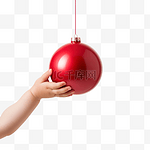 宝宝的手伸向圣诞树上的红色圣诞装饰品