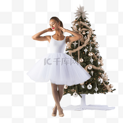 快乐跳舞的女孩图片_圣诞树附近穿着白色芭蕾舞短裙和