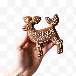 一只手拿着鹿形状的圣诞姜饼
