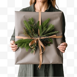 手中的树叶图片_女性手中的圣诞树花环和灰色包装