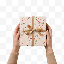 手握包装礼品盒和圣诞贺卡在木桌