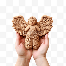 一只手拿着天使形状的圣诞姜饼