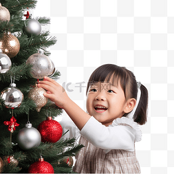 家庭享受图片_亚洲小女孩正在装饰圣诞树，享受