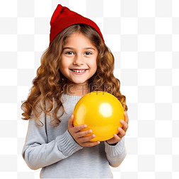 抱球孩子图片_戴着圣诞帽的小女孩在黄墙上拿着
