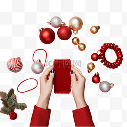女手拿着靠近圣诞物品的红色手机