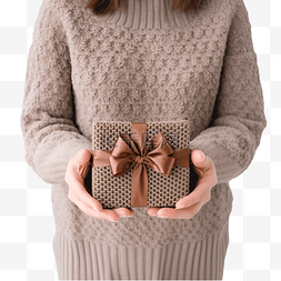 手放在针织毛衣里，拿着礼物盒